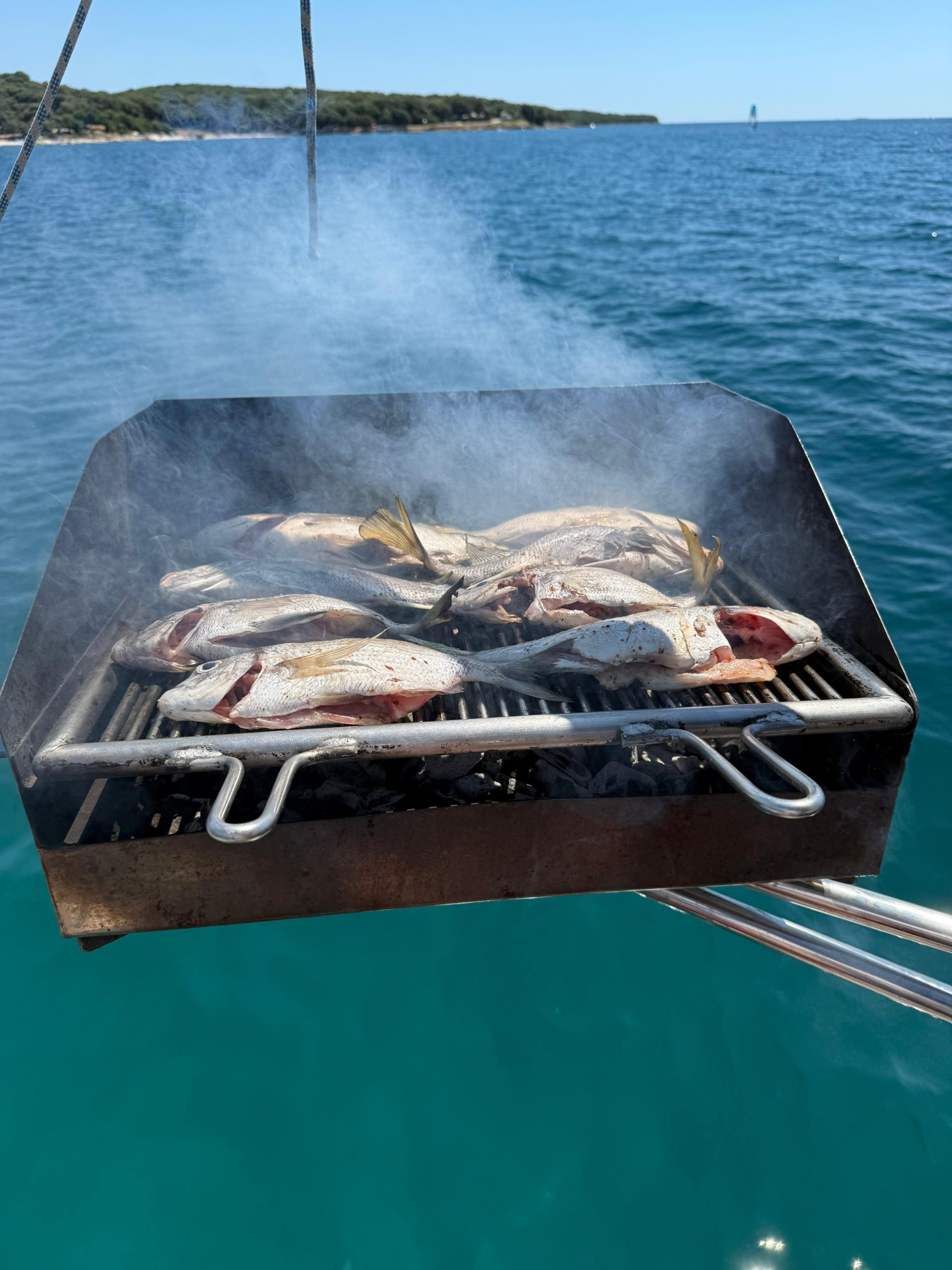 Set Sail from Rovinj in 2025: Lux Nautic Introduces Calypsa, the Crewed Sailing Yacht 1 Fresh fish grilling on Calypsa's rail‑mounted charcoal BBQ